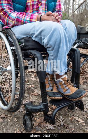 A disabled woman enjoys nature at a campsite. Being in a wheelchair doesn't stop her from enjoying the outdoors. Stock Photo