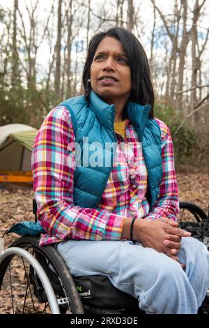 A disabled woman enjoys nature at a campsite. Being in a wheelchair doesn't stop her from enjoying the outdoors. Stock Photo