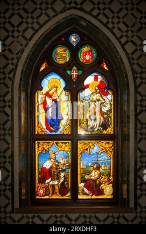 Stained-Glass window inside the Chapel, Our Lady of Pena, at the Pena Palace (Palácio da Pena) above Sintra, Portugal.  The panels of the window were commissioned in 1840 by King Ferdinand II (1816-1885) a German prince who reigned by marriage to Portuguese Queen Maria II as King of Portugal from 1837 to 1853.  Ferdinand II commissioned the German Kellner workshop in Nuremberg, Germany to create the panels of the window. Stock Photo