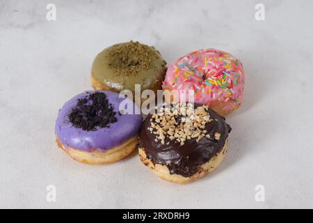 Delicious sweet donuts with different flavors on a table. Isolated image on white background Stock Photo