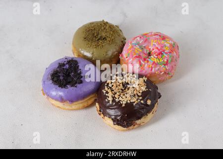 Delicious sweet donuts with different flavors on a table. Isolated image on white background Stock Photo