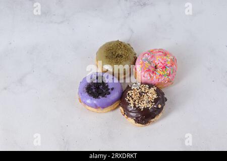 Delicious sweet donuts with different flavors on a table. Isolated image on white background Stock Photo