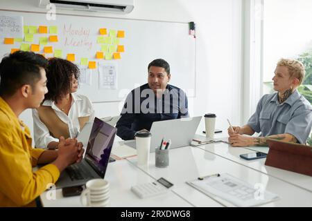 Diverse team talking in weekly meeting, discussing new strategy of development Stock Photo