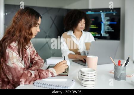 Young female UI designer working on wireframe of project website Stock Photo