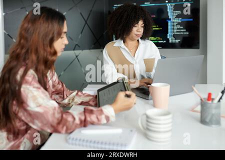 Team of UI and UX designers working on project at table in modern office Stock Photo