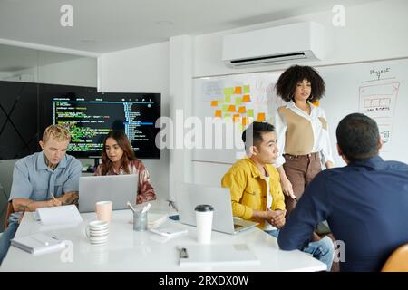 Team working on new big project discussing programming code and mobile app interface Stock Photo