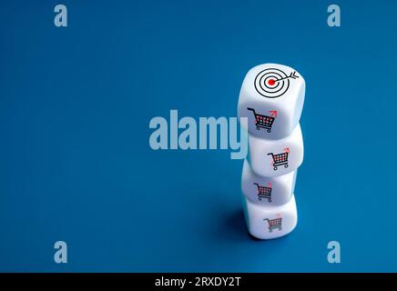 Target icon on top of white cube block stack with red growth graph shopping cart, sales increase icons on blue background with copy space. Business gr Stock Photo