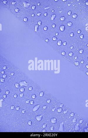 Water drops on purple background top view. Purple water drops wallpaper. Abstract water drops background for design with  copy space. Stock Photo