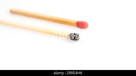 Close-up of one burned match and one brand new isolated on white background. Individuality and leadership, burnout at work and energy. Stock Photo