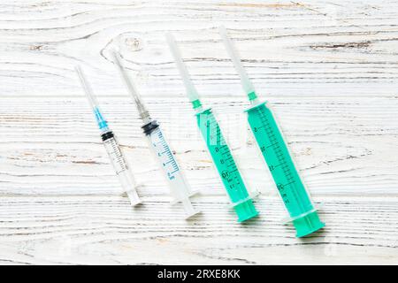 Top view of syringes of different sizes on wooden background. Medical equipment for injection concept with copy space. Stock Photo