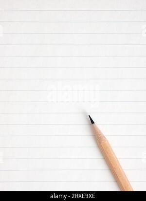 Graphite pencil on a blank or empty striped notebook page. Stock Photo