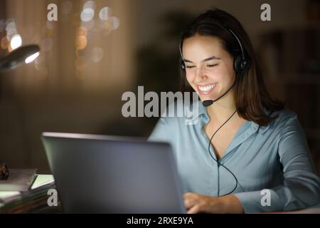 Happy tele marketer working in the night at homeoffice Stock Photo