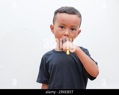 little asian boy brushing teeth on white background with copy space. children's dental health concept Stock Photo