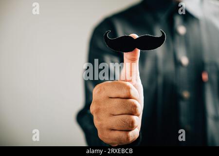 In support of Prostate Cancer Awareness, a man holds a mustache with fun and dedication Stock Photo