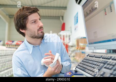 standing business man working on computer in a warehouse Stock Photo