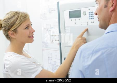 engineer training female apprentice on cnc machine Stock Photo