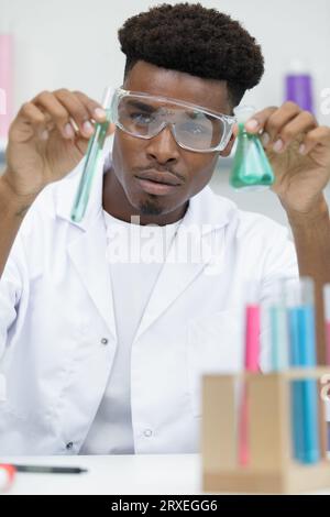 young man scientist using auto-pipette with flask Stock Photo