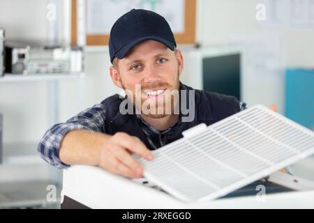 technician assembling an air-conditioning unit Stock Photo