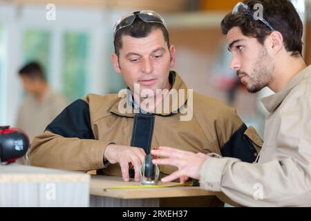 portrait of woodworkers measuring plank Stock Photo