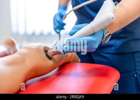 Physical therapy of the shin with shock wave, extracorporeal shockwave therapy. Stock Photo