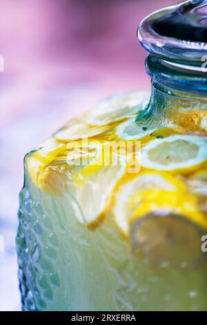 Close up, cropped view of sliced lemons in a glass container of lemonade. Stock Photo