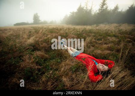 Man relaxes in foggy field Stock Photo
