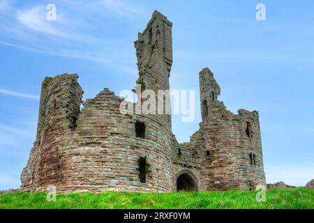 The ruins of Dunstanburgh Castle at the North Sea coastline in Northumberland, England Stock Photo