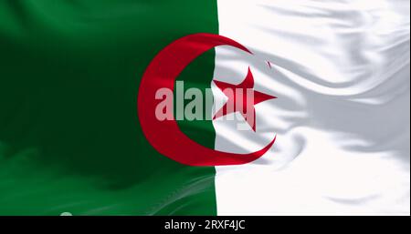 Close-up of national flag of Algeria waving on a clear day. two vertical bars, green and white, with a red star and crescent in the center. Stock Photo