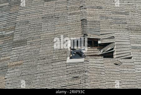 The big hole at the old roof of house, damaged roof, space for text and design. Stock Photo