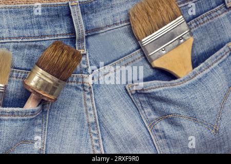 Old home repair tools in jeans pockets. Old and dusty tools. Close up Stock Photo