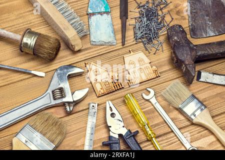 Old, dusty home tools for repair work. Light wooden background. Flat lay Stock Photo