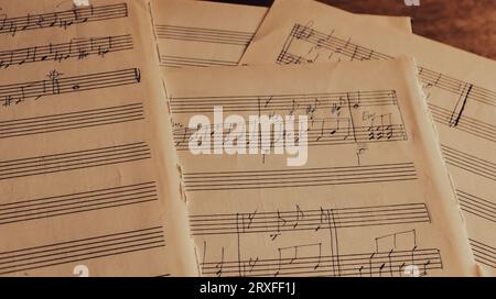 Notes on paper. Old music sheet. Melody on page. Notes and lines. Music concept. Rhythm on vintage blank. Sound symbols and signs. Clef and notes. Stock Photo