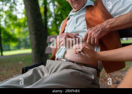 Nurse injecting insulin in belly of diabetic senior patient. Stock Photo