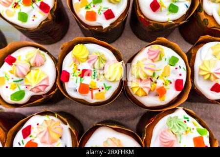 Easter cake, pie. Kulich, pie wrapped in paper. Easter cupcake with white glaze Stock Photo