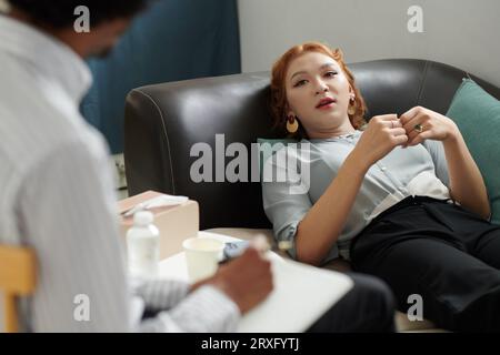 Young woman talking about her problems during therapy session Stock Photo