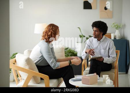 Serious psychotherapist talking to client in his office Stock Photo