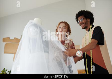 Excited fashion designers creating beautiful wedding gown Stock Photo
