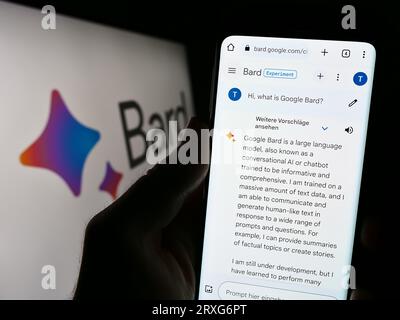 Person holding cellphone with webpage of generative AI chatbot Google Bard on screen in front of logo. Focus on center of phone display. Stock Photo