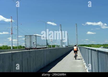 Cyclist crossing the Olivier-Charbonneau A-25 bridge, between Montreal and Laval, province of Quebec, Canada Stock Photo