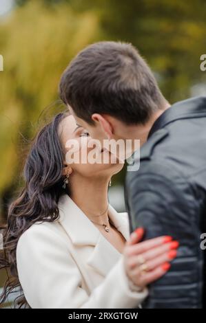 Happy husband hugs and kisses his pregnant wife. Portrait of a married ...