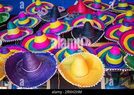 Set of Mexican hats of cheerful colors placed in typical stand for festival days Stock Photo