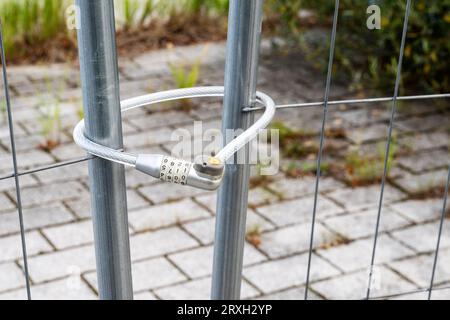 A construction fence was locked with a bicycle lock for bicycles Stock Photo