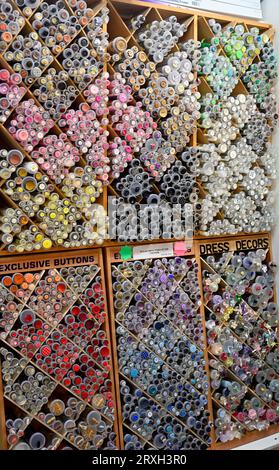 Sew n Sew haberdashery inside the Bath Guildhall Market with very extensive range of buttons in display rack, UK Stock Photo