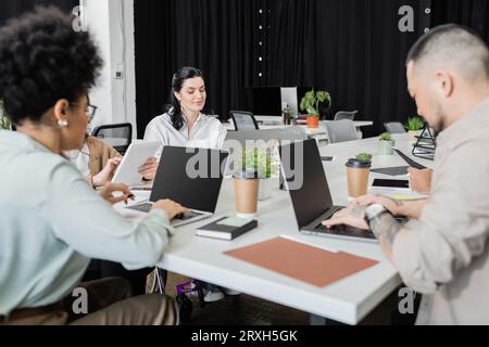 busy hours in modern coworking, multicultural team working on startup project and using devices Stock Photo