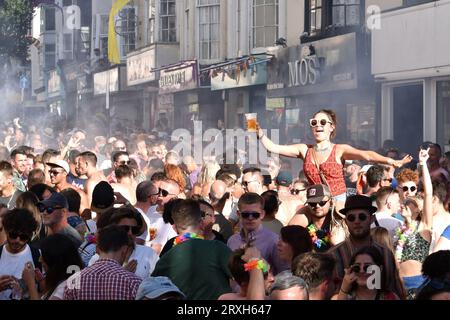 Brighton and Hove, United Kingdom, August 5 2018: Woman with pint of beer lifted above crowd during annual Pride celebrations Stock Photo