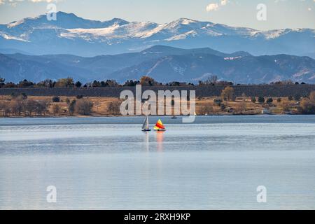 A peaceful Autumn day at Cherry Creek State Park in Colorado, with Sailboats on the lake and the Mountains visible in the background. Stock Photo