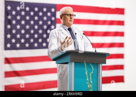 Mature doctor giving a speech at a conference on a podium in the USA Stock Photo