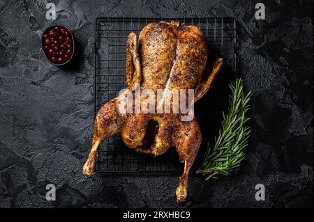 Roast whole duck, festive christmas recipe. Black background. Top view. Stock Photo