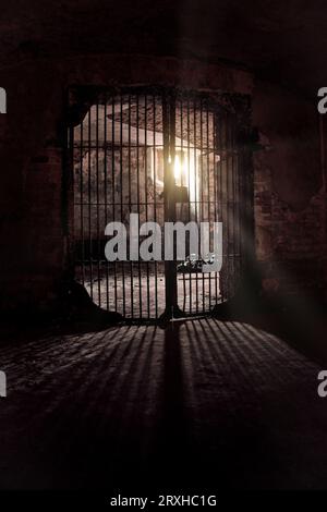 Light glowing from Iron grate in old cellar. Stock Photo