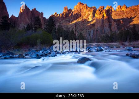 Motion blur of the current of the Crooked River running in the foreground through the rugged landscape in Smith Rock State Park of Oregon, USA Stock Photo
